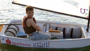 Nahaufnahme Junge segelt im Segelboot Optimist