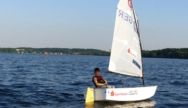 Junge im Segelboot Optimist auf dem Schweriner See